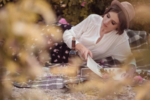 güzel kız kitabı ile şapka giymiş çim üzerinde oturan gül gaden