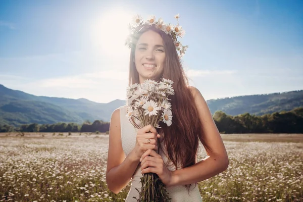 Papatya alanı üzerinde gülümsüyor güzel genç kız.