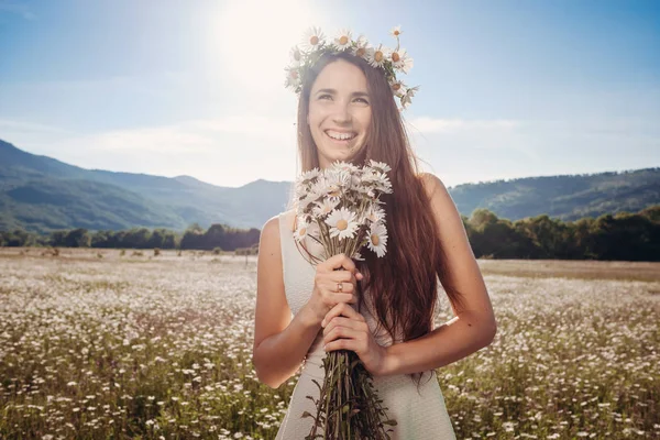 Papatya alanı üzerinde gülümsüyor güzel genç kız.