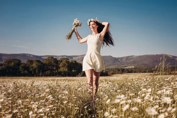 Papatya alanı üzerinde gülümsüyor güzel genç kız.