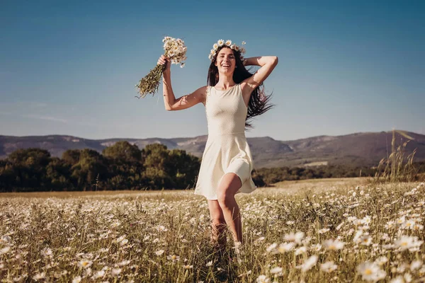 Papatya alanı üzerinde gülümsüyor güzel genç kız.