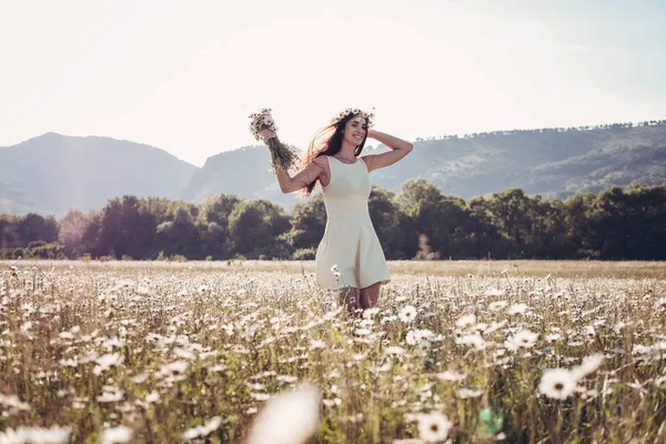Papatya alanı üzerinde gülümsüyor güzel genç kız.
