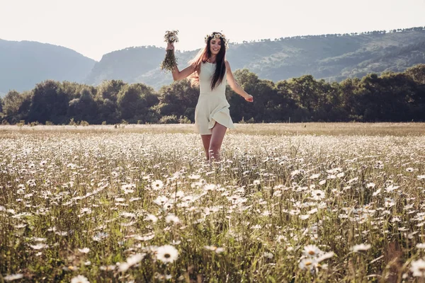 Menina bonita sorrindo sobre camomila campo . — Fotografia de Stock
