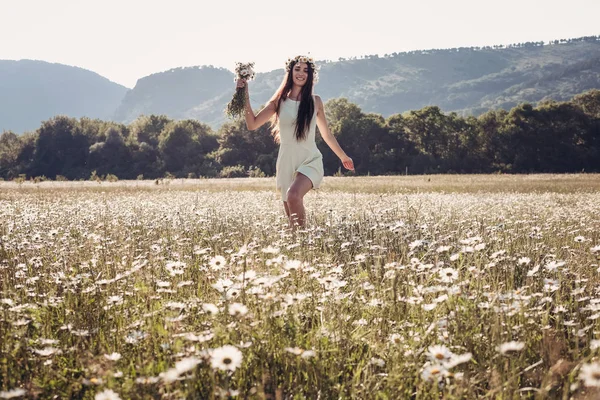 Menina bonita sorrindo sobre camomila campo . — Fotografia de Stock