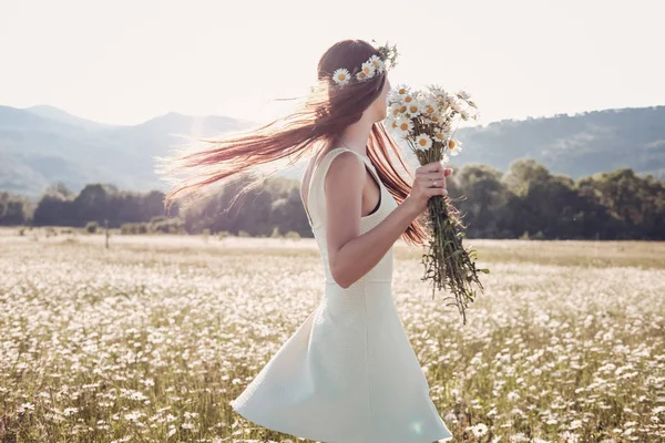 Красива молода дівчина посміхається над ромашковим полем . — стокове фото
