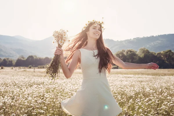 Papatya alanı üzerinde gülümsüyor güzel genç kız.