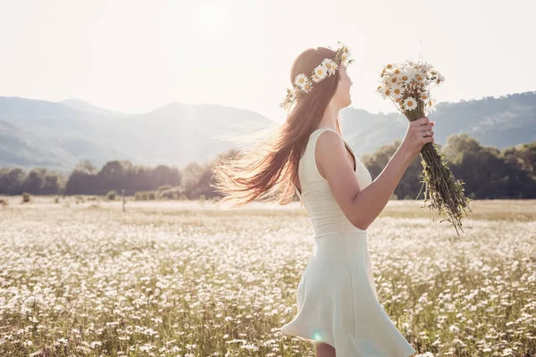 Papatya alanı üzerinde gülümsüyor güzel genç kız.