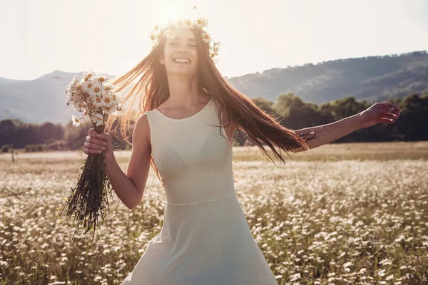Papatya alanı üzerinde gülümsüyor güzel genç kız.