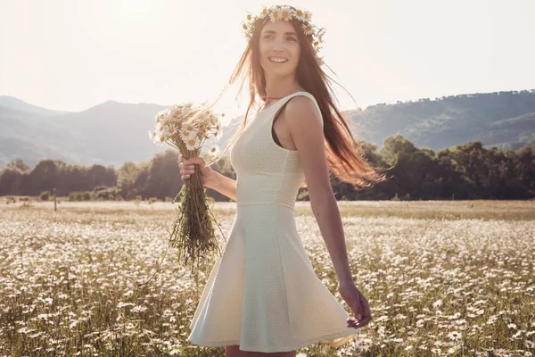 Papatya alanı üzerinde gülümsüyor güzel genç kız.