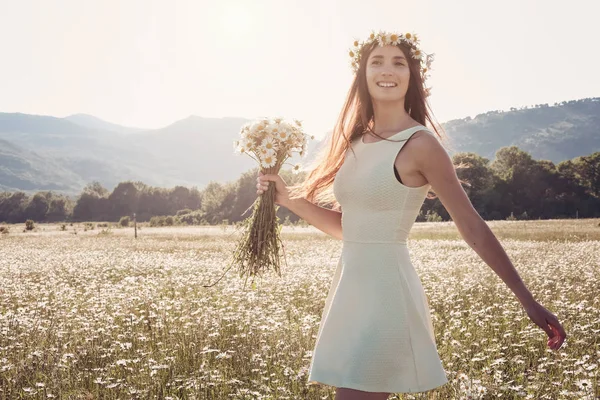 Papatya alanı üzerinde gülümsüyor güzel genç kız.