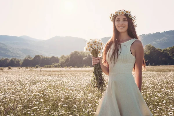 Papatya alanı üzerinde gülümsüyor güzel genç kız.