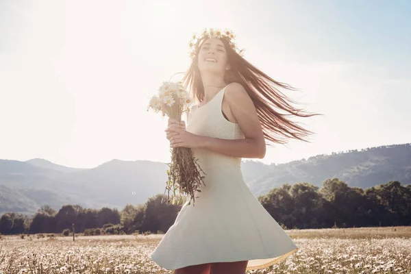 Papatya alanı üzerinde gülümsüyor güzel genç kız.