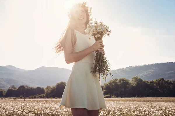 Papatya alanı üzerinde gülümsüyor güzel genç kız.
