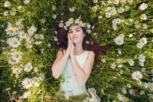 La hermosa mujer yace en el campo de las manzanillas — Foto de Stock