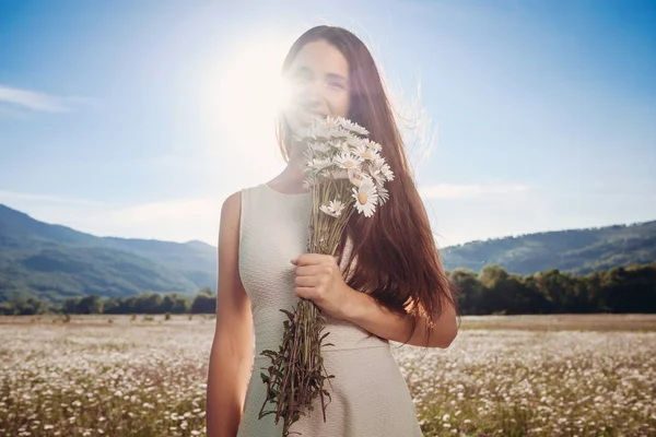Papatya alanı üzerinde gülümsüyor güzel genç kız.