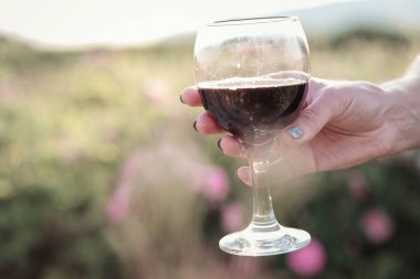 Güllerin yanında poz veren kıvırcık saçlı güzel bir kadın.