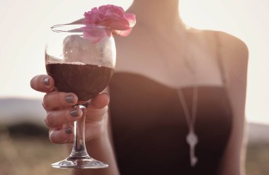 Güllerin yanında poz veren kıvırcık saçlı güzel bir kadın.