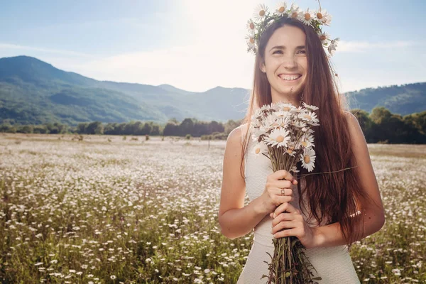 Papatya alanı üzerinde gülümsüyor güzel genç kız.