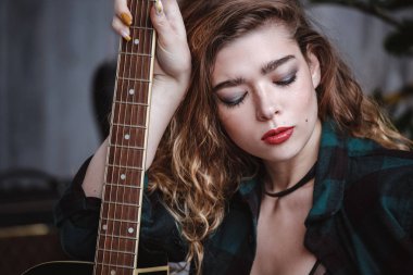 Rock civciv tema. Çekici beyaz kadın uzun sarı saç kot pantolon ve ince kayışları ile siyah bir üst giyiyor