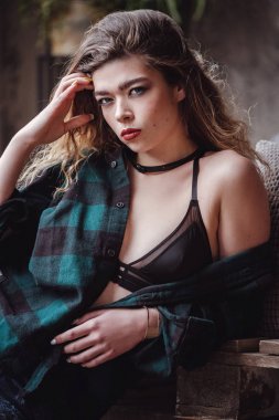 Rock civciv tema. Çekici beyaz kadın uzun sarı saç kot pantolon ve ince kayışları ile siyah bir üst giyiyor