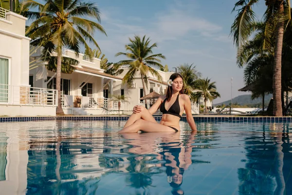 Tiro de una joven mujer relajándose en la piscina de lujo. Vacaciones de verano . —  Fotos de Stock