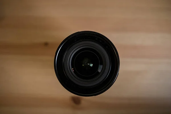A lente da câmera na mesa de madeira clara — Fotografia de Stock