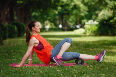 Genç bir kadın parkta özel bir silindir ile uzanan yok.