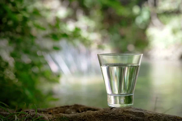 A glass of clean water, on the nature. Concept of a healthy life