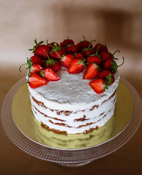 La torta hermosa con las fresas y la crema a la mesa — Foto de Stock