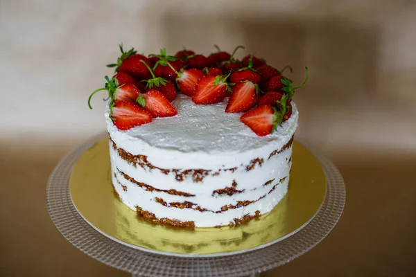 Piękny tort z truskawkami i śmietaną na stole — Zdjęcie stockowe