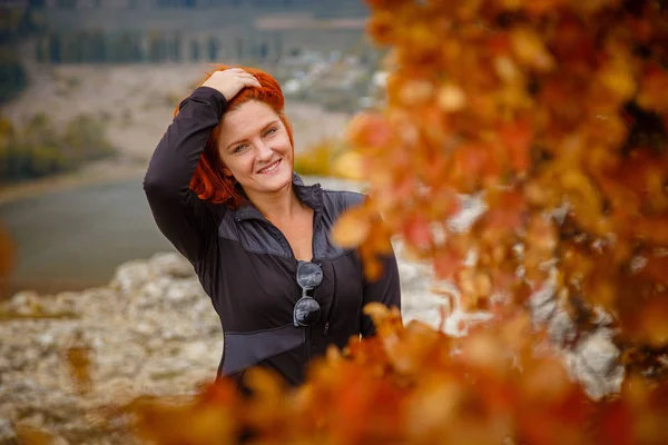 Elegante signora dai capelli rossi con gli occhi chiusi che riposa nella natura in montagna nel prato — Foto Stock