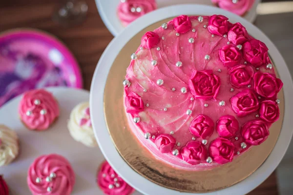 Beau gâteau rose avec des décorations sur la table . — Photo