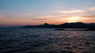 Güneşin okyanusun üzerinde battığı güzel uçurumlar. Sahilde güzel bir gün batımı, inanılmaz renkler, deniz manzarasında parlayan ışık demeti. Deniz gün batımı. 