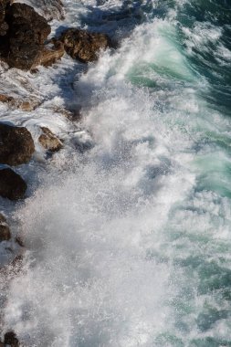 Okyanus dalgası arka planı deniz suyunu kırıyor kayalık kıyı dalgalı deniz turkuaz su gradyan köpüğü. Açık denizde büyük dalgalar. Yaz musonu. Bir deniz dalgasının beyaz tepesi.