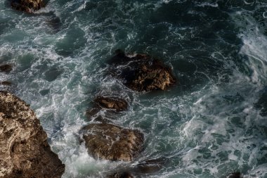 Okyanus dalgası arka planı deniz suyunu kırıyor kayalık kıyı dalgalı deniz turkuaz su gradyan köpüğü. Açık denizde büyük dalgalar. Yaz musonu. Bir deniz dalgasının beyaz tepesi.