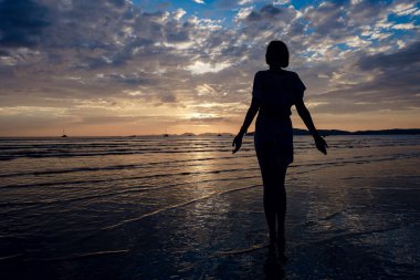 Mutlu Kaygısız Kadın Sahilde Güzel Günbatımının tadını çıkarıyor. Tayland 'ın Krabi eyaletindeki ünlü Ao Nang plajı.