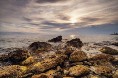 Dramatik gün batımı. Dalga yıpranmış kayaların ve kayaların üzerinden akıyor. Öndeki doğal bir gölet. Hdr işlendi.
