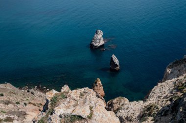 Mavi denizdeki uçurumdan güzel bir manzara. Denizde serbest kayalıkları olan inanılmaz bir sahil. Cape Fiolent, Kırım.