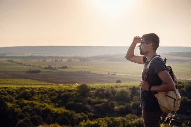 Güneş batarken bir dağın tepesinde duran bir adam. Hedefler ve başarılar konsept fotoğraf birleşimi. Kavramsal görüş, dağ yürüyüşü ve güneşin doğuşunun keyfini çıkar.
