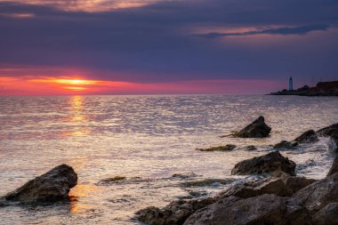 Dramatik gün batımı. Dalga yıpranmış kayaların ve kayaların üzerinden akıyor. Öndeki doğal bir gölet. Hdr işlendi.