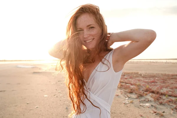 美丽的年轻女士 有着长长的健康的红头发和可爱的白色衣服在湖边散步 炎热的夏夜日落了生活方式概念 — 图库照片