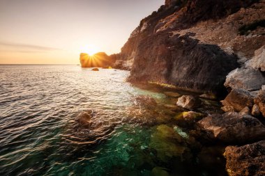Denizin üzerinde güzel bulutlu bir manzara, güneşin doğuşu. Alacakaranlıkta tropikal bir göl manzarası. Uzun pozlu çekim. Boşluğu resmin seçimine kopyala.