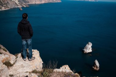 Turist akıllı telefondan deniz kıyısındaki bir uçurumdan inanılmaz manzaralı bir fotoğraf çekiyor. fikir ve seyahat, tatil ve keşif konsepti