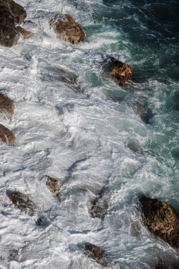 Okyanus dalgası arka planı deniz suyunu kırıyor kayalık kıyı dalgalı deniz turkuaz su gradyan köpüğü. Açık denizde büyük dalgalar. Yaz musonu. Bir deniz dalgasının beyaz tepesi.