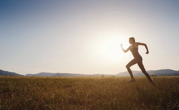 Μια Γυναίκα Που Τρέχει Στο Καλοκαιρινό Χωράφι Ηλιοβασίλεμα Γυναίκα Γυμναστήριο — Φωτογραφία Αρχείου