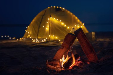 Sahildeki gece yangını. Yaz havası. Deniz kıyısında retro bir çelenkle gece kampı..