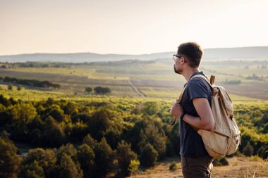 Güneş batarken bir dağın tepesinde duran bir adam. Doğanın günbatımının tadını çıkarıyorum. Gün doğumunda dağlarda dinleniyorlar. Trek konsepti
