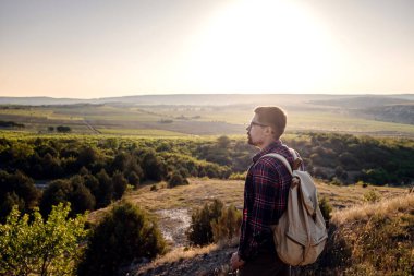 Güneş batarken bir dağın tepesinde duran bir adam. Hedefler ve başarılar konsept fotoğraf birleşimi. Kavramsal görüş, dağ yürüyüşü ve güneşin doğuşunun keyfini çıkar.