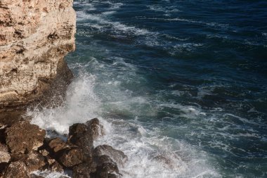 Okyanus dalgası arka planı deniz suyunu kırıyor kayalık kıyı dalgalı deniz turkuaz su gradyan köpüğü. Açık denizde büyük dalgalar. Yaz musonu. Bir deniz dalgasının beyaz tepesi.