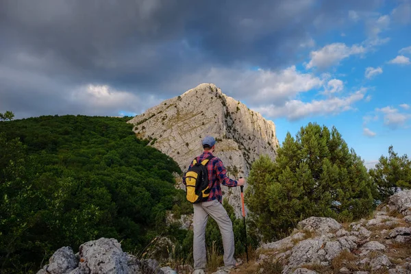 年轻人在夏日落山时站在悬崖顶上欣赏自然风光 — 图库照片